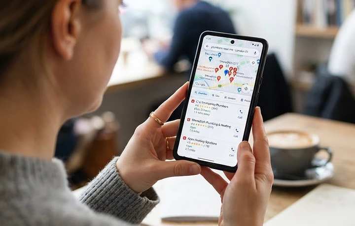 A person searching Google on their phone for a local service, with nearby local business results and a map