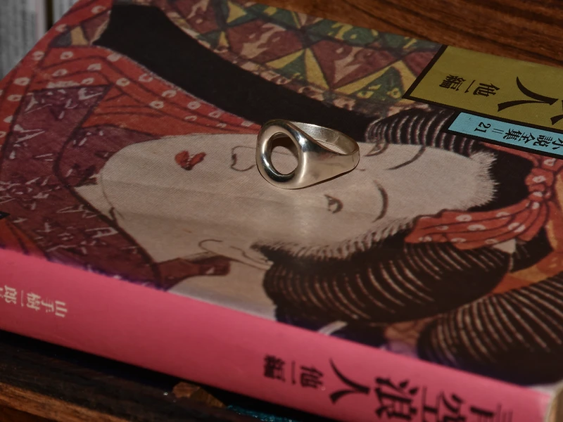 Silver ring resting on a Japanese book cover