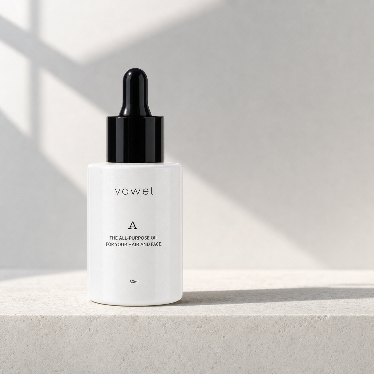 The vowel A bottle centered on a pale stone surface with a sharp diagonal shadow