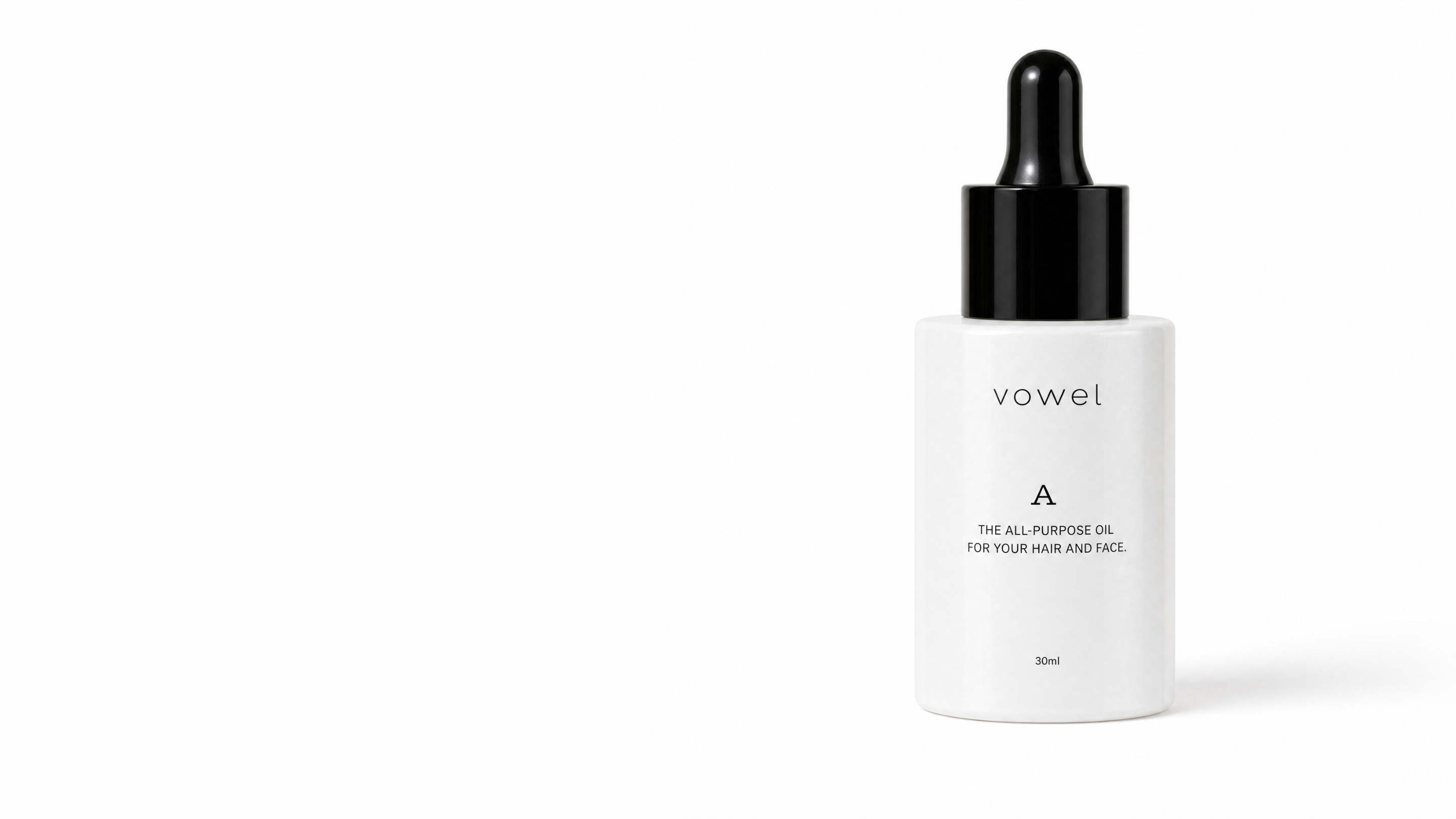 The white vowel A oil bottle with a black dropper cap on an off-white background