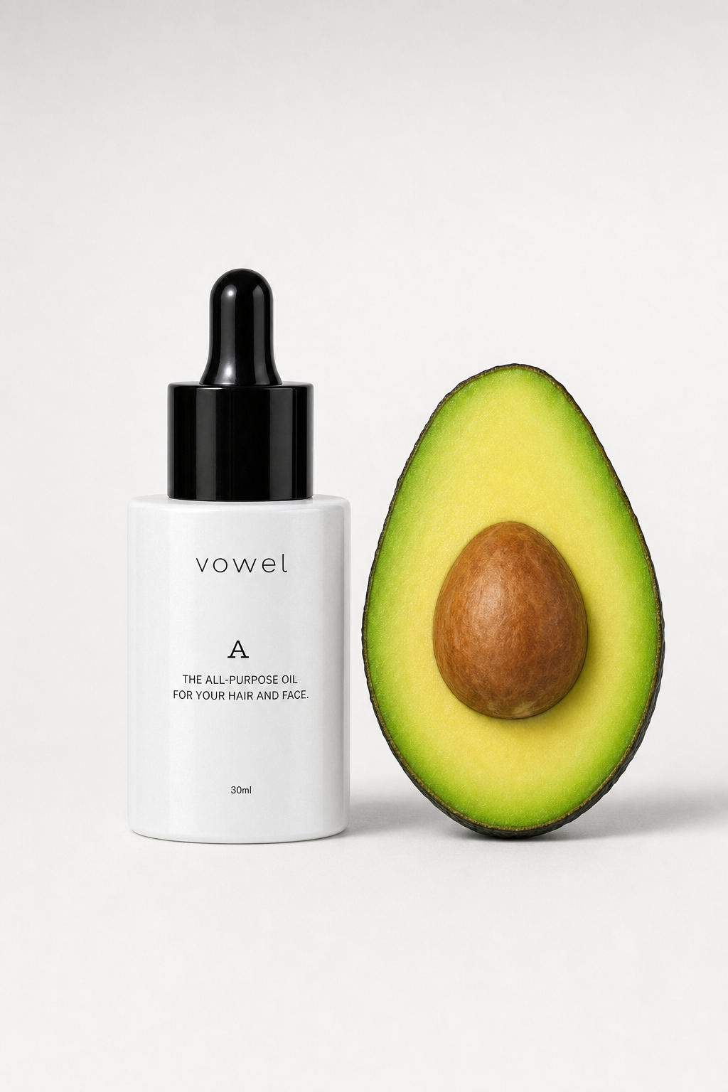 vowel A oil bottle beside a halved avocado