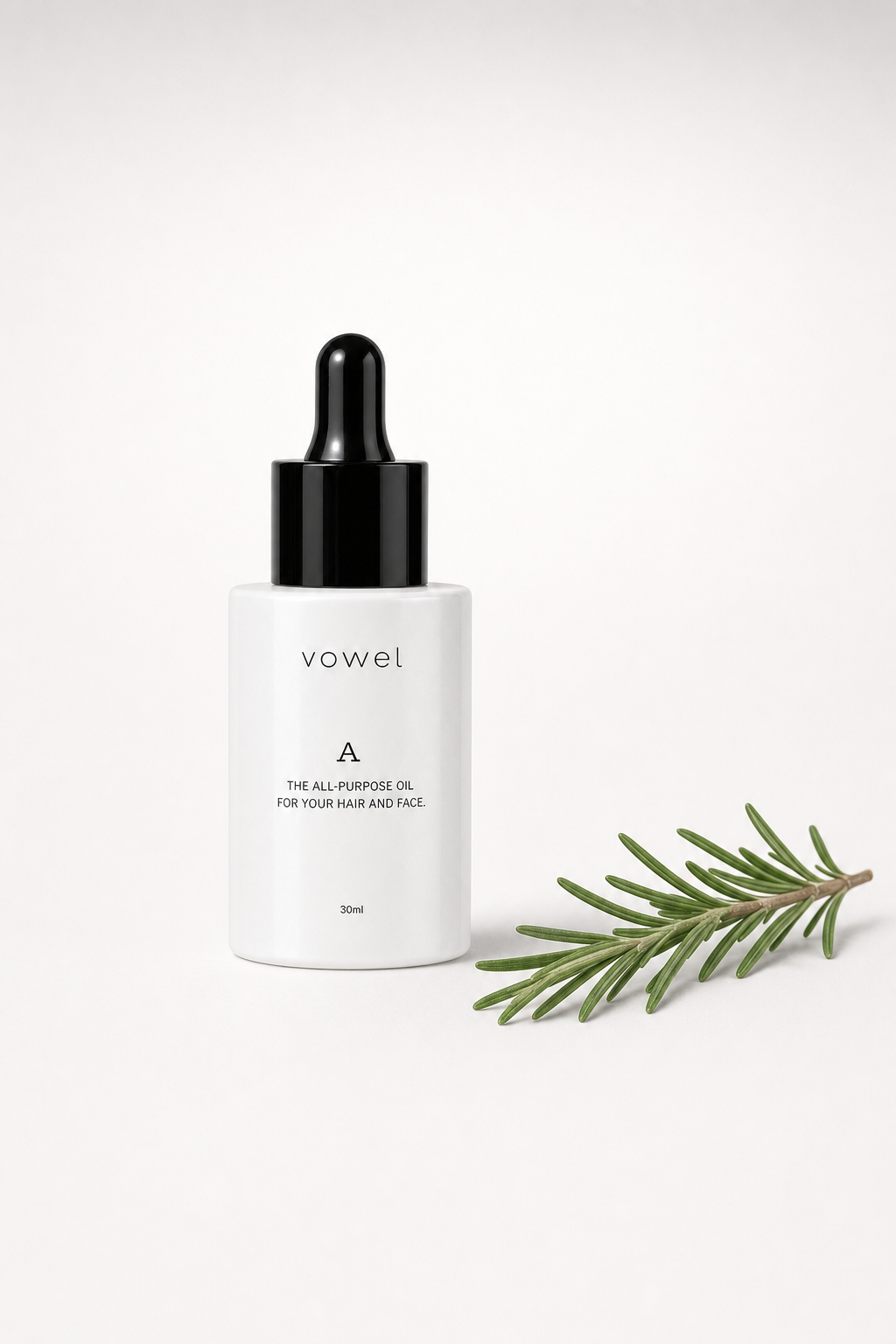 vowel A oil bottle beside a sprig of rosemary