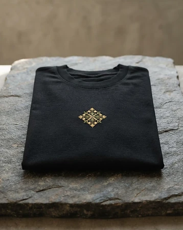 Heritage Tee — Organic black cotton tee with embroidered chest detail.
