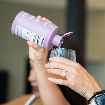 Hands pouring Nutriplus Glow supplement into a glass