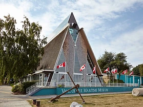 The Vancouver Maritime Museum building with its distinctive A-frame roof and Canadian flags