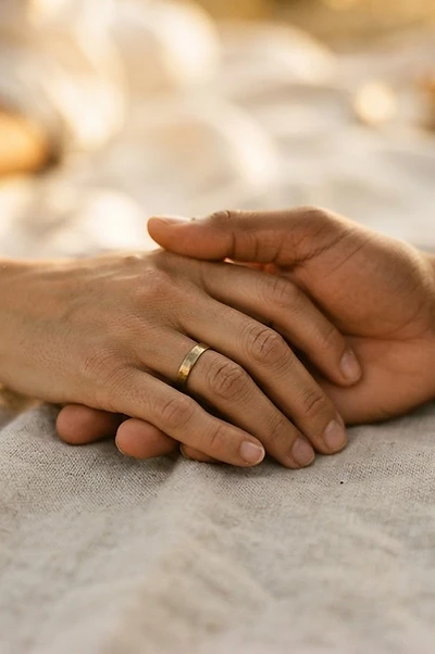 Two couples' hands clasped together at a New England wedding ceremony