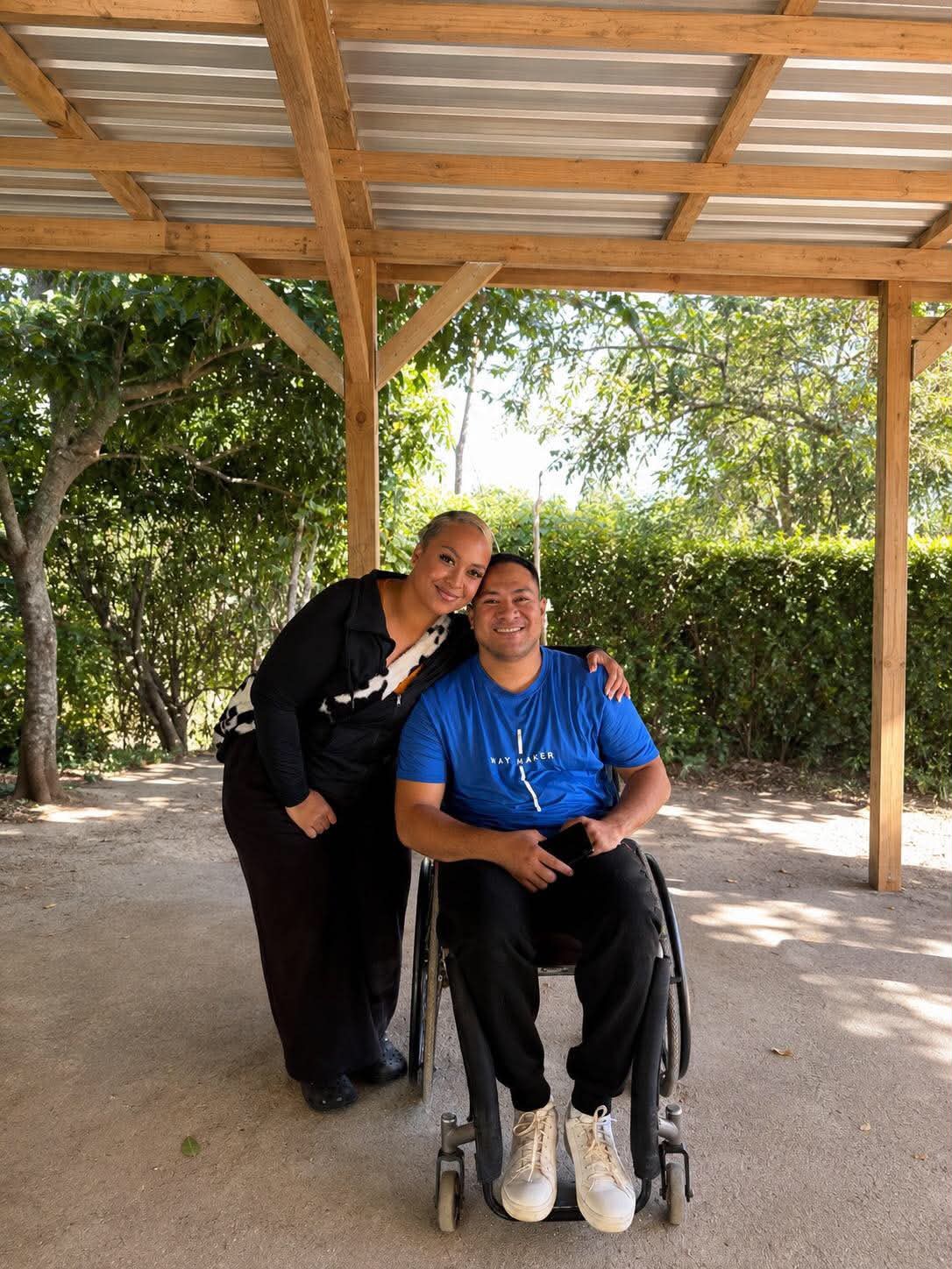 A Daybound member and companion smiling together under a pavilion on an outdoor outing