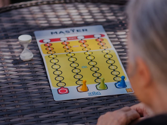 Two people playing a colorful board game together at an outdoor table