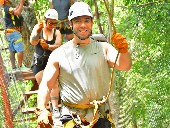 Members climbing a high-ropes course together on a community engagement outing