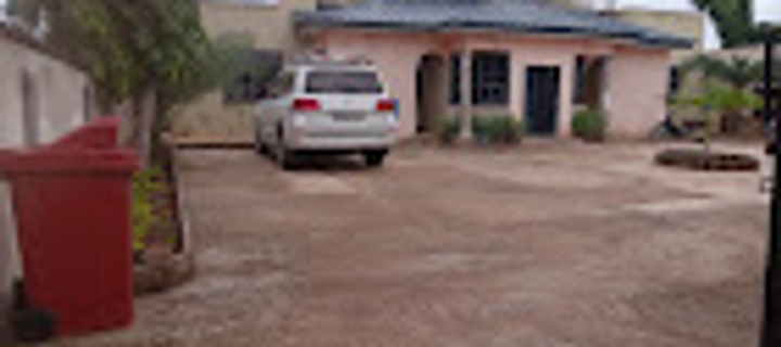 Sinsaba Lodge courtyard with paved grounds and evergreen trees