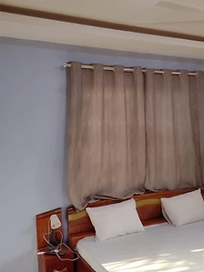 Guest room with wooden bed, white linen, ceiling fan and wall-mounted air conditioning