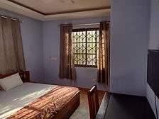 Window with sheer curtains and patterned bed runner in warm natural light