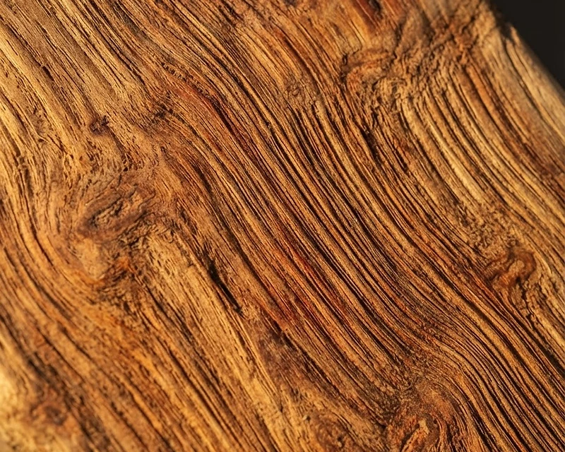 Raw teak wood grain texture rising from the workshop floor