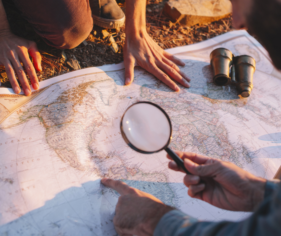 Research maps, magnifying glass and fieldwork planning materials