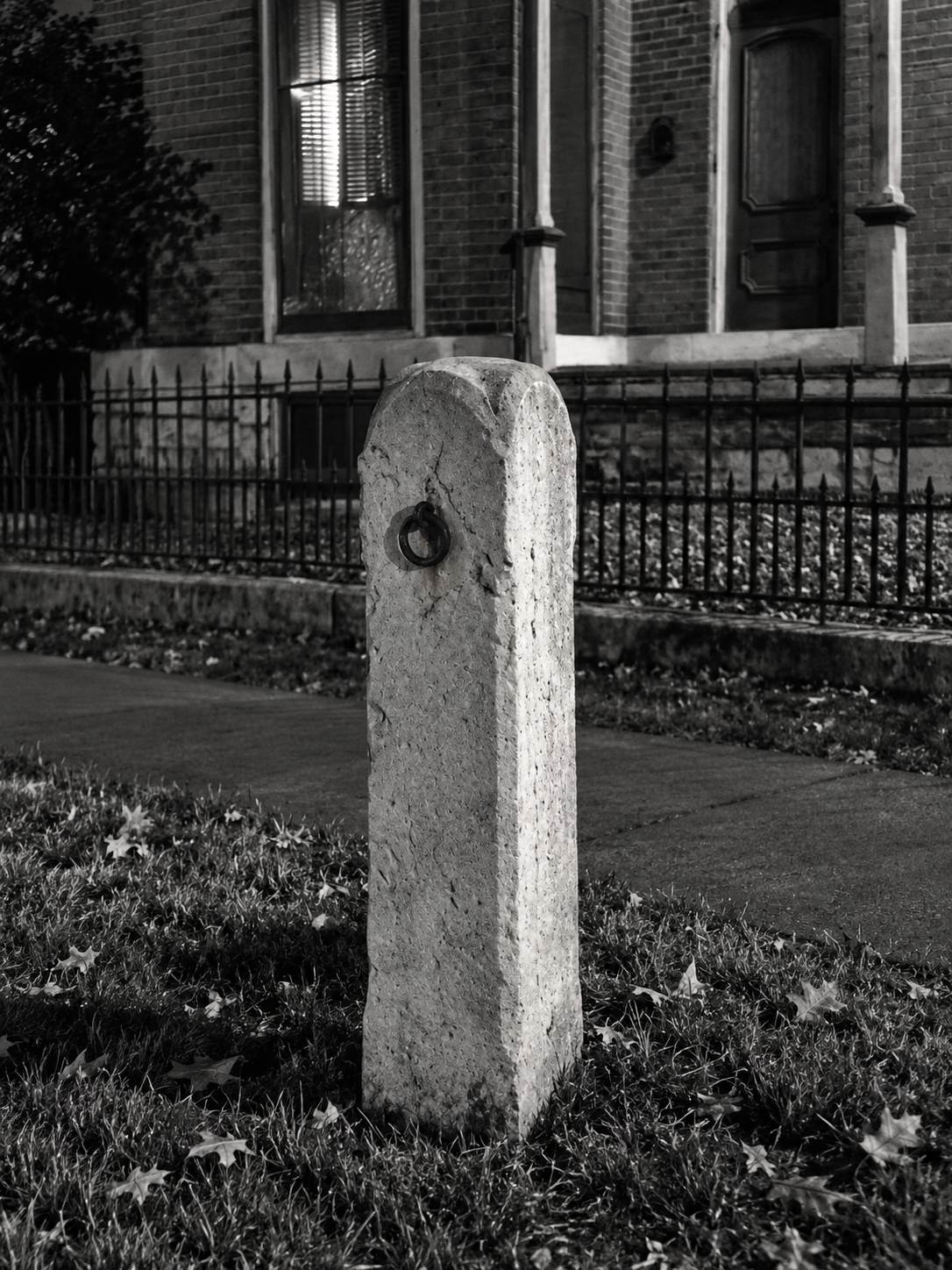 Weathered stone hitching post with surviving iron ring at the Kelly Family Home, photographed by Helena B. Scott