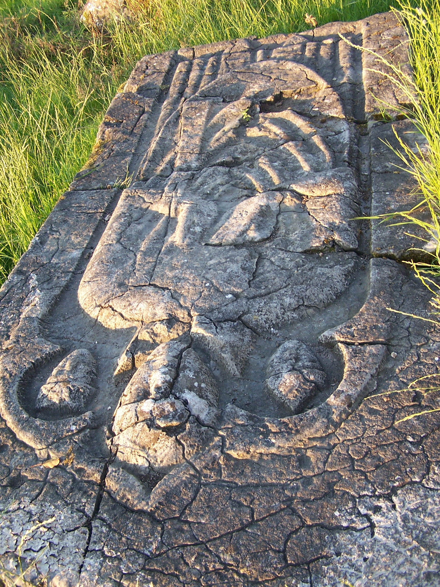 Legendary grave stone of St Nicholas at Newtown Jerpoint, County Kilkenny, showing the clerical figure and two carved heads traditionally associated with the knights who brought his remains to Ireland