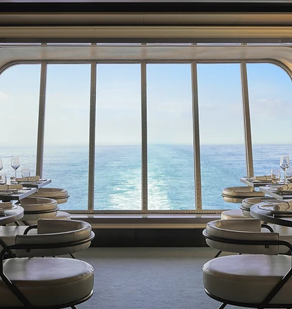 Ocean horizon through a panoramic window aboard a Virgin Voyages ship
