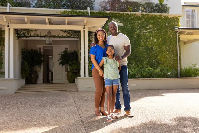 A family standing in front of their home