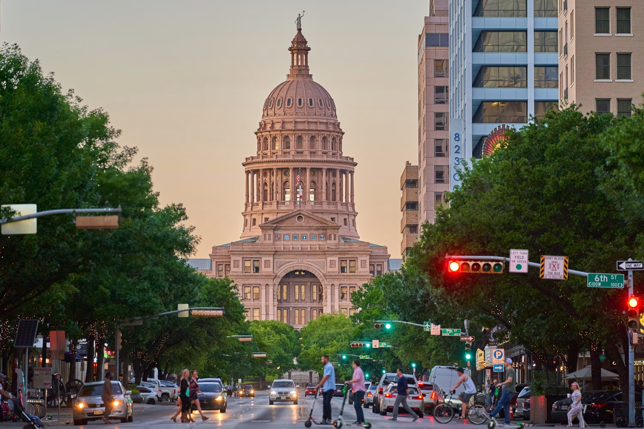 The Texas State Capitol in Austin at golden hour, framed by trees along Congress Avenue