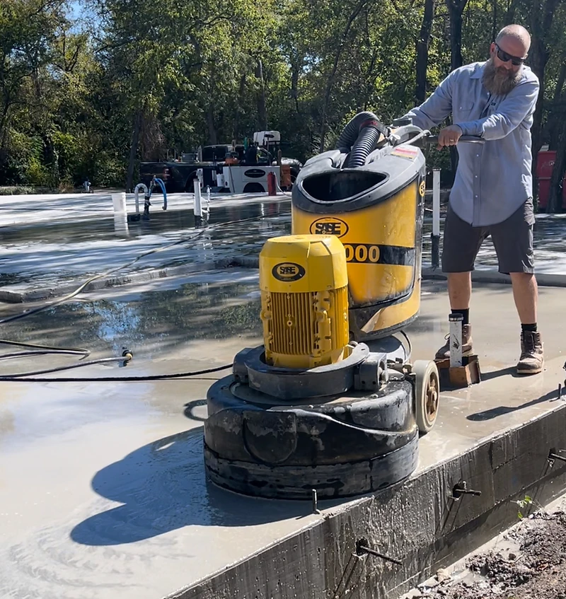 Jeremy Redig grinding concrete on an outdoor slab with an SASE grinder