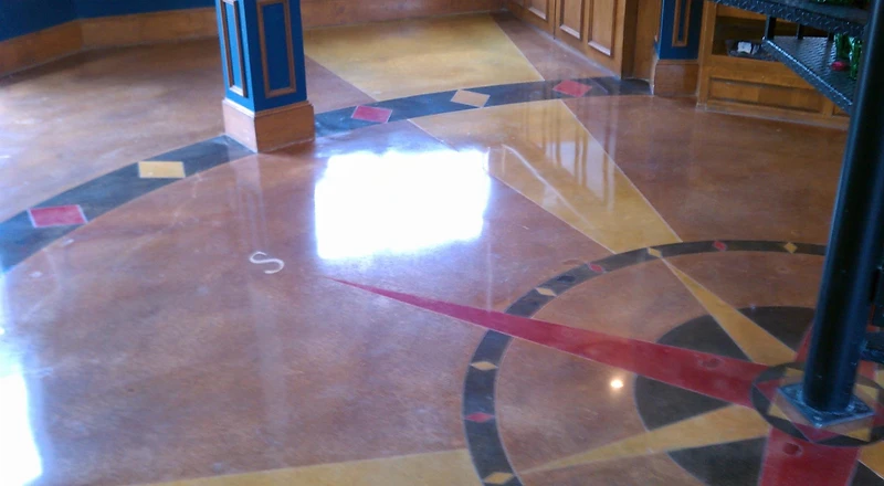 Polished stained concrete floor with a nautical compass-rose inlay