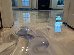 Finished white and gray metallic epoxy floor in a residential living space — the result of the project