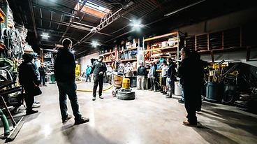 Instructor teaching a crew around floor grinding equipment inside the CCS warehouse