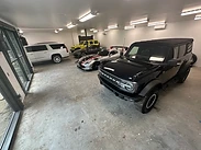 Existing garage space assessed before floor coating work begins — vehicles, lighting, and substrate conditions evaluated