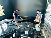 Two installers rolling metallic epoxy on a vaulted garage floor — metallic epoxy training