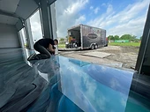 Installer using a power tool on the edge of a metallic epoxy floor during surface preparation