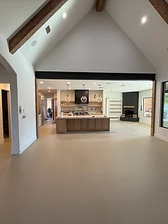 Completed light-gray cement overlay floor in an open-plan living space with vaulted ceilings