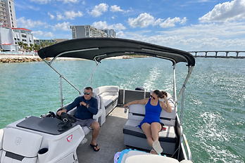 Captain Mark at the helm with a guest on a private Clearwater pontoon charter