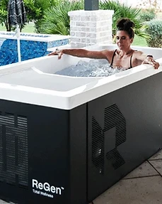 Cold plunges for recovery Matte black cold plunge tub on a stone patio beside a pool