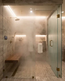 Modern luxury steam shower with stone tile and glass enclosure.
