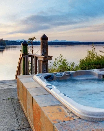 Hot tub overlooking a lake at sunset
