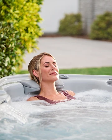 Woman relaxing in a bubbling hot tub on a quiet morning