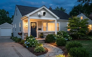 Security camera mounted under the eave of a home at dusk