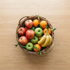 Fijn Mini fruitmand met vers fruit op een eikenhouten tafel