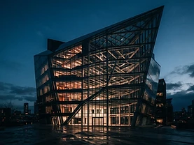 Modern glass office building at dusk with sharp architectural angles