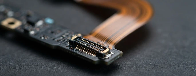 Macro view of a battery connector and copper ribbon cable on a workbench