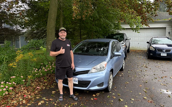 Man with blue Toyota Yaris hatchback