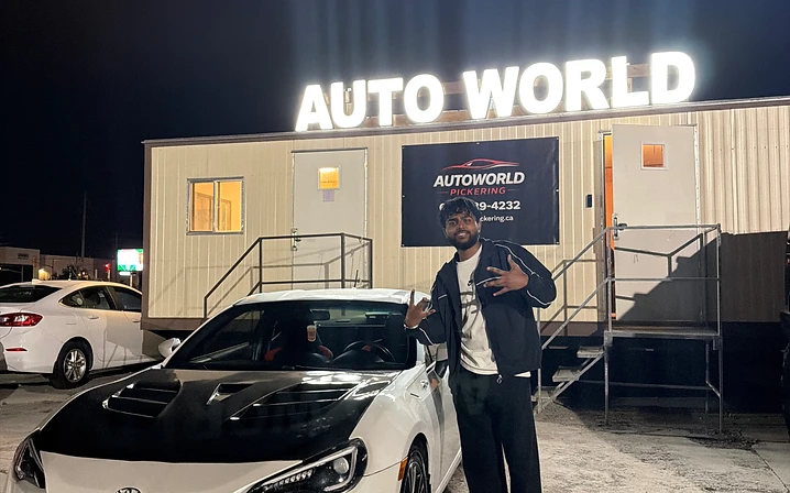 Man with white Toyota sports car at night