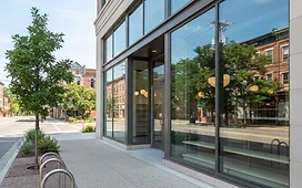 A modern glass storefront with clean windows, illustrating commercial window cleaning in Plymouth, Michigan.