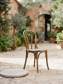 A quiet, sunlit courtyard with a single wooden chair