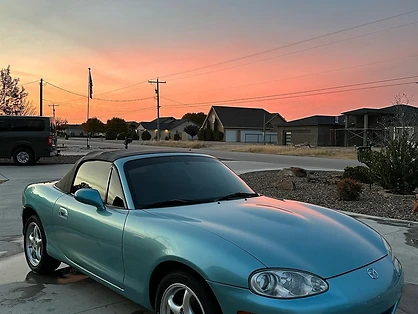 Clean sports car parked outdoors at sunset after a hand wash and exterior detail