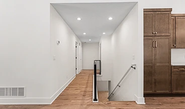 Hallway with vaulted ceiling and staircase