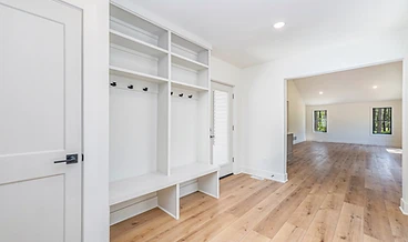 White built-in mudroom leading into the main living space