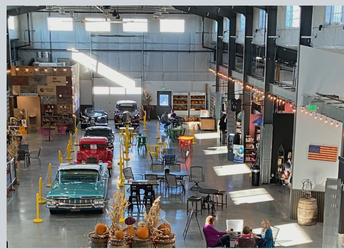 The Quincy Public Market hall with classic cars, seating, and string lights