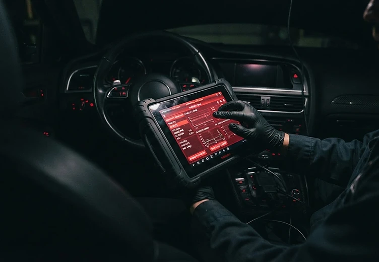 Mechanik korzystający z tabletu diagnostycznego w samochodzie
