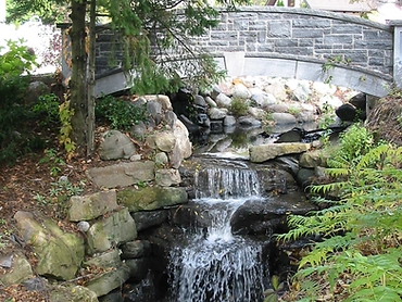 Cascade et bassin sous un pont de pierre